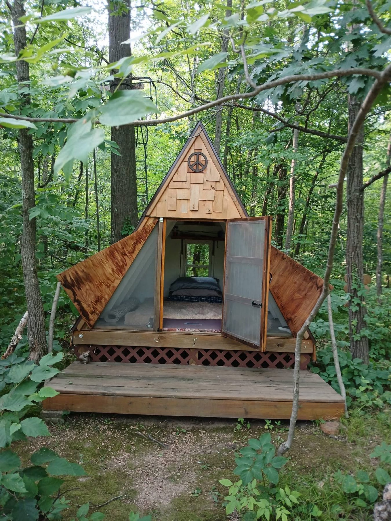 The Karner Blue A-frame cabin, its door open onto the bed inside